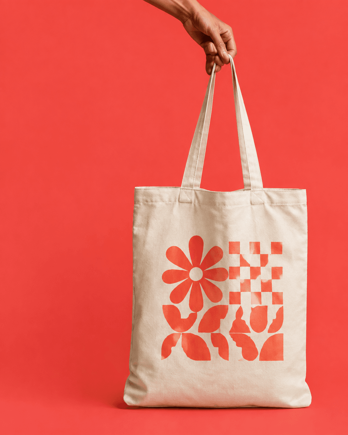 Cream custom printed tote bag held against a coral backdrop